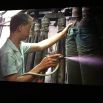 Chinese denim factory: worker spraying deadly toxins to distress and colour the fabric without mask; the workers drastically shorten their lives, while the toxins run straight into the river polluting drinking water and all the surrounds downstream
