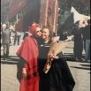 Mother and daughter on graduation day, Auckland,New Zealand, Maori carved statue in the background
